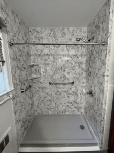 Black and white shower with grab bars in Long Island, New York